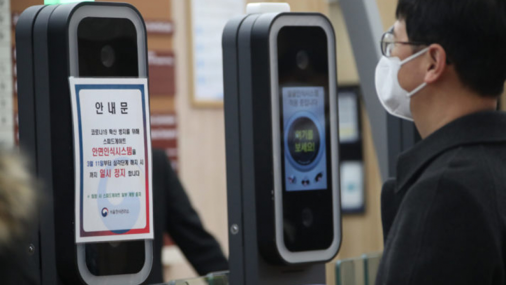New coronavirus A government employee enters a gate of the government complex in Seoul on March 11, 2020, with a face mask on, as the operation of a facial recognition system to enter the complex has been suspended amid the spread of the new coronavirus.